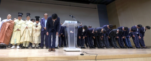 Mayor An Byeong-gu (front) of Miryang, South Gyeongsang Province, bows along with government officials and community leaders of the city in a public apology issued jointly for the 2004 Miryang gang rape case, at the Miryang City Hall on Tuesday. (Yonhap)