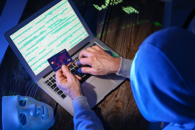 This rendered image shows a hacker using a laptop and a credit card for cyber attack. (123rf)