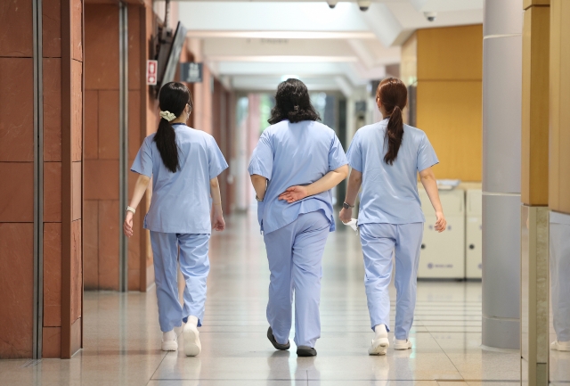 Medical workers walk in a hallway at a general hospital in Seoul on Sunday. (Yonhap)