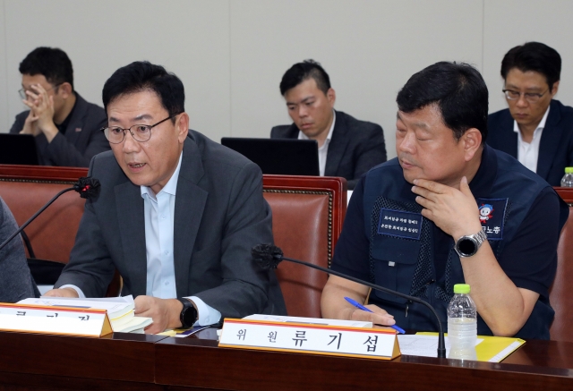 Ryu Gi-jeong (left), an executive at the Korea Enterprises Federation and a member of the Minimum Wage Commission, speaks during the commission's meeting at the government complex in the central city of Sejong on Tuesday. (Yonhap)