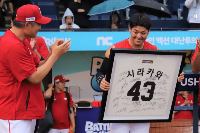 SSG Landers pitcher Keisho Shirakawa (right) holds a framed jersey given to him by manager Lee Sung-yong (left) during a ceremony at Changwon NC Park in Changwon, South Gyeongsang Province, Tuesday. (Yonhap)