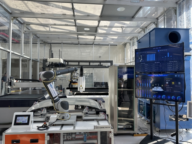 The Korea Electronics Technology Institute’s robot, which sands the roof of a car, is being tested at the Robot Plus Test Field in Suseo on June 18. (Lee Jung-joo/The Korea Herald)