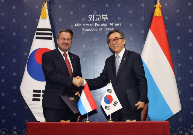 South Korea's Foreign Minister Cho Tae-yul (right) and Luxembourg's Deputy Prime Minister Xavier Bettel shake had after signing a memorandum of understanding on a working holiday program, Wednesday. (Yonhap)