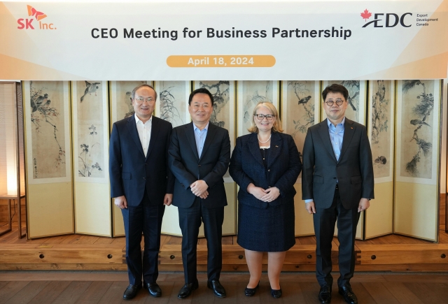 SK Inc. CEO Jang Yong-ho (center left) and Export Development Canada CEO Mairead Lavery (center right) pose for a photo after a strategy meeting in Seoul in April. (SK Group)