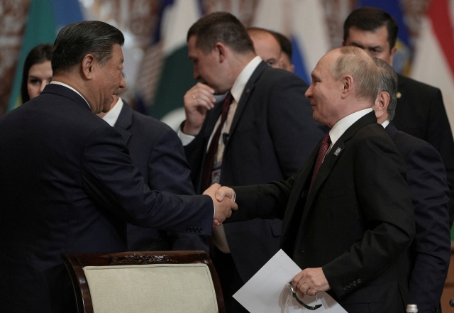 Russian President Vladimir Putin shakes hands with Chinese President Xi Jinping at Shanghai Cooperation Organization (SCO) summit in Astana, Kazakhstan, on Thursday. (Reuters)