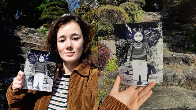 Marrit van der Staaij holds up a baby picture of her mother while standing on the steps of her mother's former foster home in Gwangju. (Marrit Kim van der Staaij)