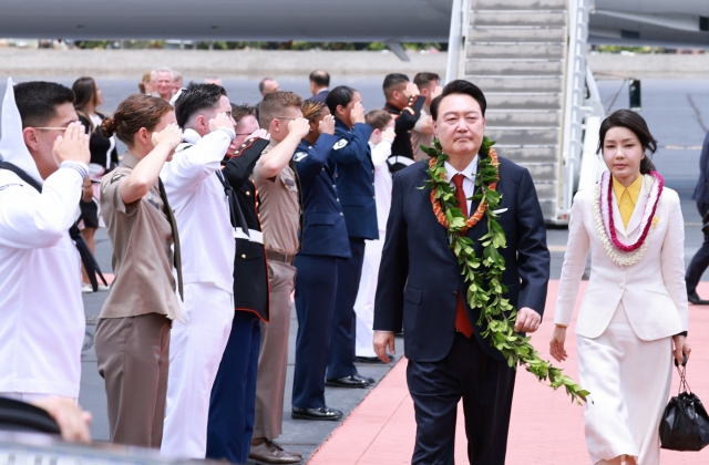 President Yoon Suk Yeol (left) and first lady Kim Keon Hee arrive at Hickam Air Force Base in Honolulu, Hawaii, on Tuesday. (Yonhap)