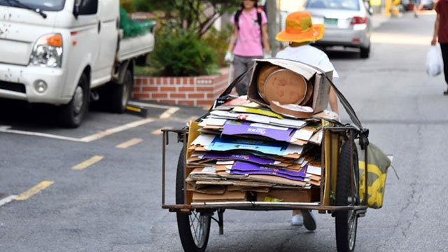 A senior citizen drags a handcart full of cardboard through the streets of Seoul. (Yonhap)