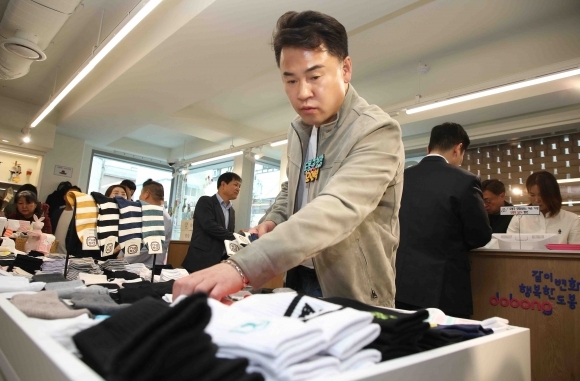 Oh Un-seok, District Head of Dobong-gu, examines socks at the 