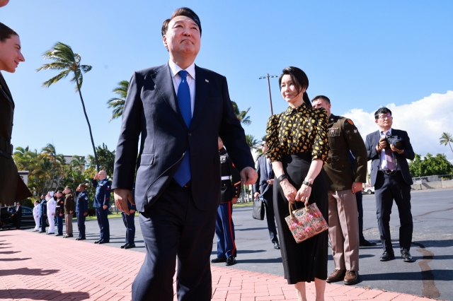 President Yoon Suk Yeol (left) and first lady Kim Keon Hee (second from left) are seen boarding Air Force One as he flew from Hawaii to Washington on Tuesday. (Yonhap)