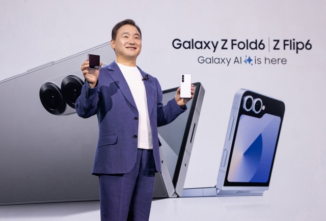 Samsung Electronics President Roh Tae-moon poses with the new Galaxy foldable smartphones at the Louvre Museum in Paris, Wednesday. (Samsung Electronics)