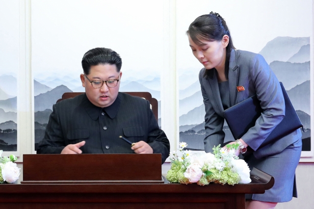 North Korea's leader Kim Jong-un (left) signs the guest book next to his sister Kim Yo-jong (right) during the Inter-Korean summit with South Korea's President Moon Jae-in (not pictured) at the Peace House building on the southern side of the truce village of Panmunjom on April 27, 2018. (AFP)