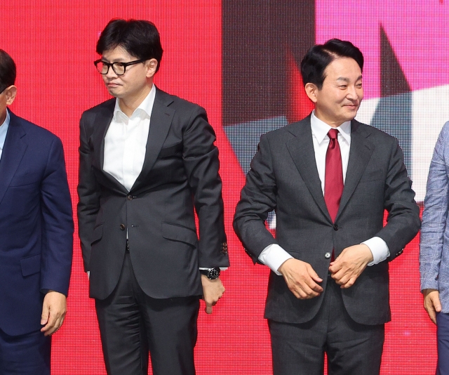 Former People Power Party interim leader and ex-Justice Minister Han Dong-hoon, left, and former Land Minister Won Hee-ryong pose for a photo at a party event held in Daegu on Friday. (Yonhap)