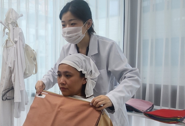 A personal color consultant conducts a color swatch test for a customer at Color Signal in Gangnam-gu, Seoul. (Choi Si-young/The Korea Herald)