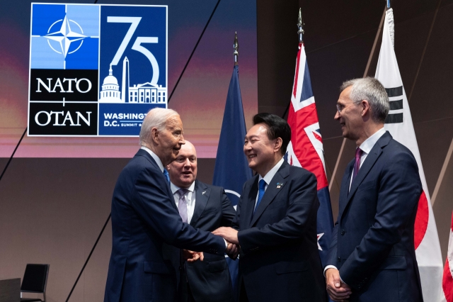 South Korean President Yoon Suk Yeol (third from left) and US President Joe Biden (second) shake hands during their meeting held on the sidelines of the North Atlantic Treaty Organization summit in Washington on Thursday. (Yonhap)