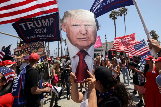 A supporter holds a portrait of former President Donald Trump during a demonstration in support of former president in Huntington Beach, California, Sunday. (Reuters-Yonhap)