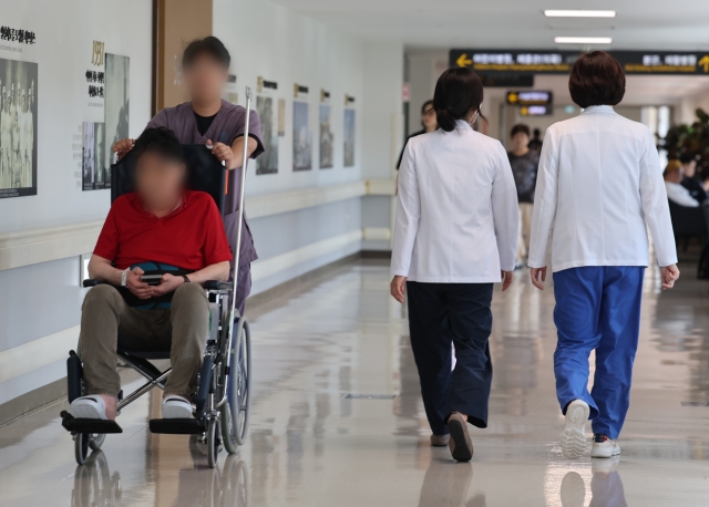 A patient and medical workers are seen at a hospital in Seoul, July 10. (Yonhap)