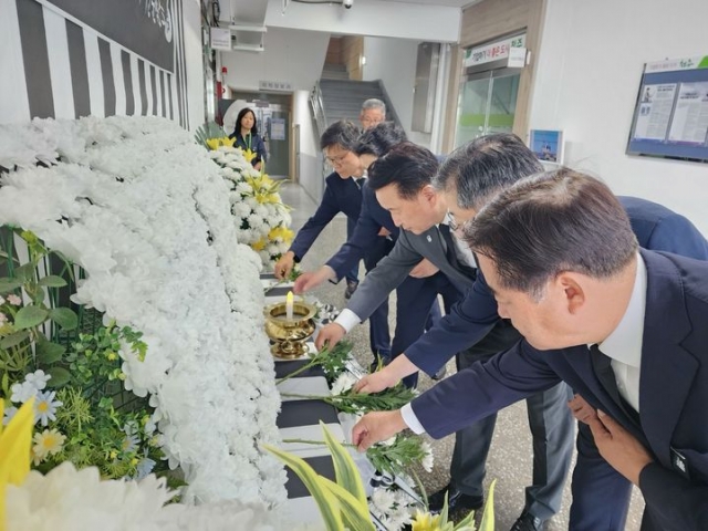 North Chungcheong Province Gov. Kim Young-hwan and provincial officials pay their respects by laying flowers at a memorial set up at Cheongju City Hall on Monday, marking the first anniversary of the Osong tragedy. (North Chungcheong Provincial Government)