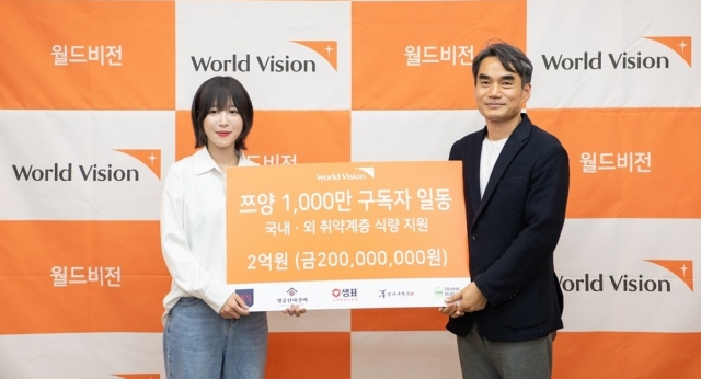 This photo shows Tzuyang (left) posing for a photo after donating 200 million won ($145,000) to the humanitarian group World Vision on Wednesday. (World Vision Korea)