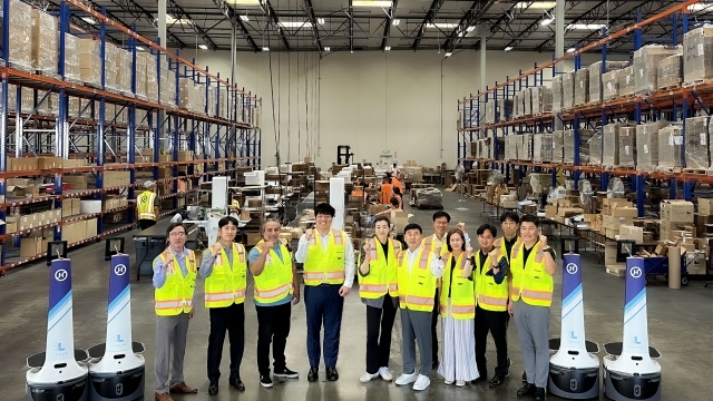 Hanjin Logistics CEO Noh Sam-sug (sixth from left), President and Chief Marketing Officer Emily Cho (fifth from left) and other company officials pose for a photo at the LA fulfillment center in the US on July 8. (Hanjin Group)