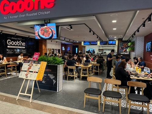 This undated photo, provided by GN Food, shows people enjoying roast chicken and side dishes at its first outlet in the Philippines. The store is located in Bonifacio Global City, a central business district in Taguig, Metro Manila. (Yonhap)