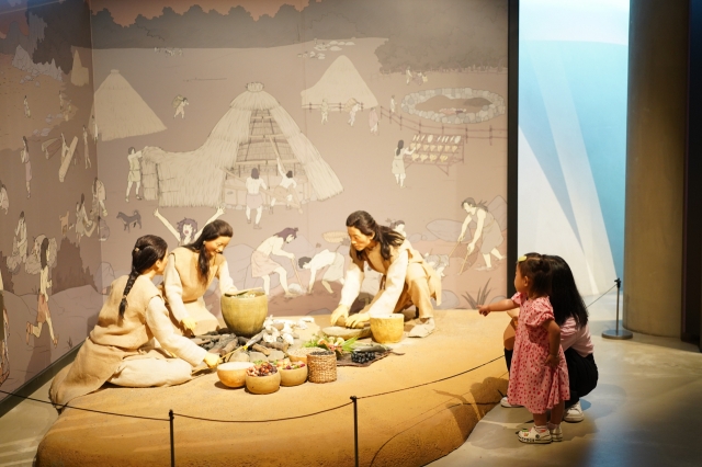 A mother and daughter explore a Neolithic Age-themed exhibition at Siheung Oido Museum in Siheung, Gyeonggi Province, Tuesday. (Lee Si-jin/The Korea Herald)