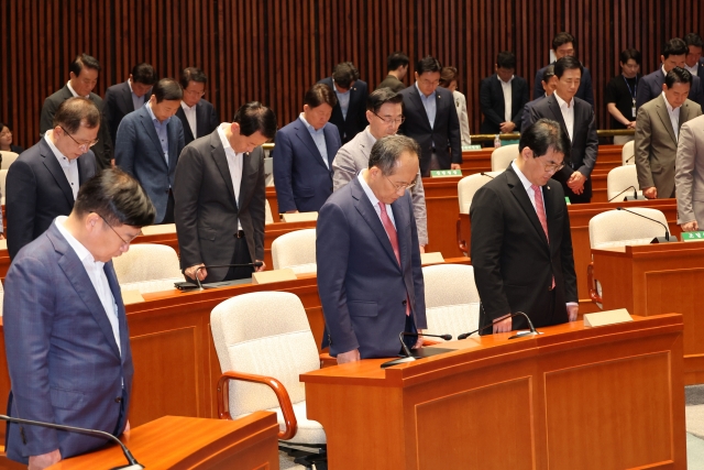 Lawmakers including People's Power Party floor leader Choo Kyung-ho observe a moment of silence at a parliamentary meeting in Yeouido, Seoul, on Friday, marking the first anniversary of a Marine's death. (Yonhap)