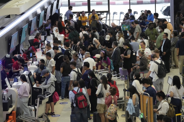 Passengers line up for check in at Don Mueang International Airport in Bangkok, Thailand, Friday, July 19, 2024. Travelers in Thailand, as in other parts of the world, were inconvenienced by a major internet outage that disrupted flights, in addition to affecting banks, media outlets and other businesses. (AP/Yonhap)