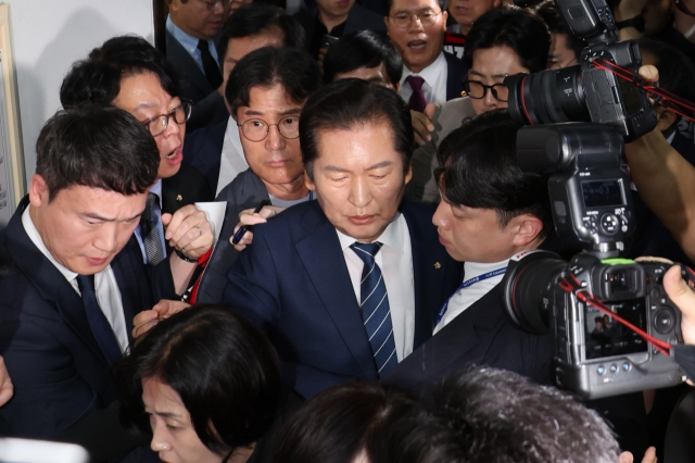 Lawmakers of the ruling People Power Party protest against a hearing on an online petition calling for the impeachment of President Yoon Suk Yeol, as Rep. Jung Chung-rae, chair of the parliamentary legislation and judiciary committee, heads to a meeting room at the National Assembly in Seoul to attend the hearing on July 19, 2024. (Yonhap)