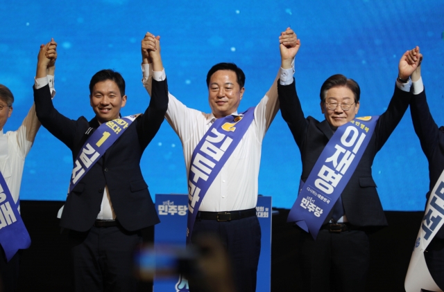 Rep. Lee Jae-myung (right), former leader of the main opposition Democratic Party of Korea, greets party members alongside former Interior Minister Kim Doo-gwan (center) and candidate Kim Ji-soo during a primary election for a new party leader in Hongcheon County, Gangwon Province, on Sunday. The event in Gangwon Province marks the second leg of the 15-stop race across the country. (Yonhap)