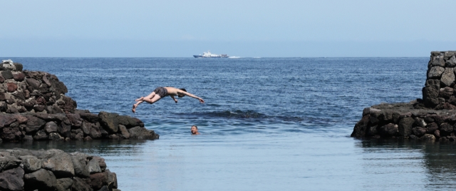 Swimmers dive into the ocean in Jeju Island, Monday, as a heat wave warning was issued with temperatures expected to feel as high as 35 degrees Celsius. (Yonhap)