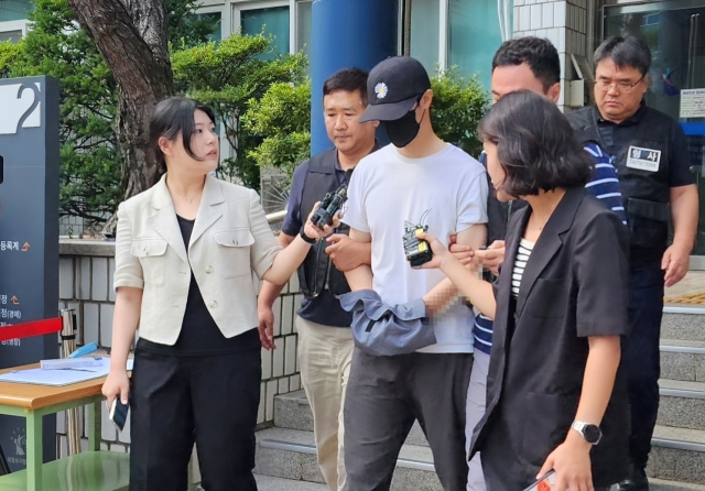 The taekwondo instructor (center) who is suspected of abusing the child to death leaves Uijeongbu District Court in Uijeongbu, Gyeonggi Province after his detention warrant review on July 14. (Yonhap)