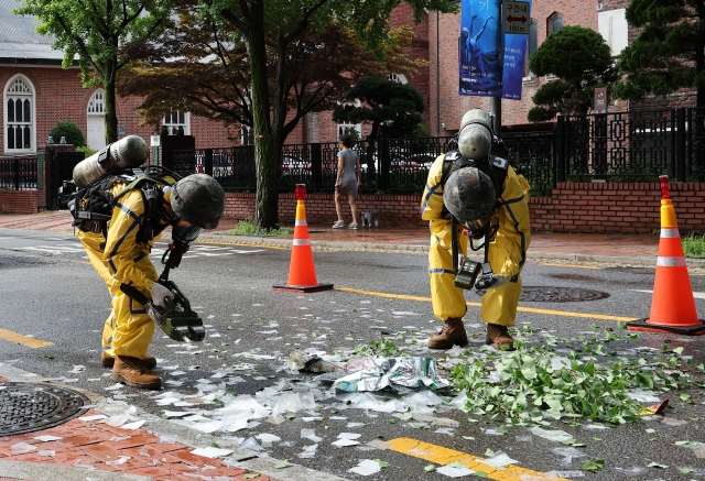 This photo shows soldiers on Wednesday morning handling waste contained in a balloon flying from North Korea near the Jeondong Theater in Jung-gu, central Seoul,. (Yonhap)