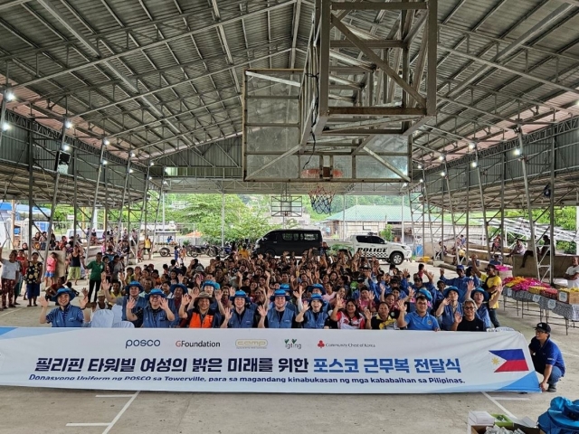 Posco employees, NGO officials and Filipino residents pose for a photo during the ceremony marking Posco Group's donation of uniforms held in Tarlac in the Philippines on July 2. (Posco Group)