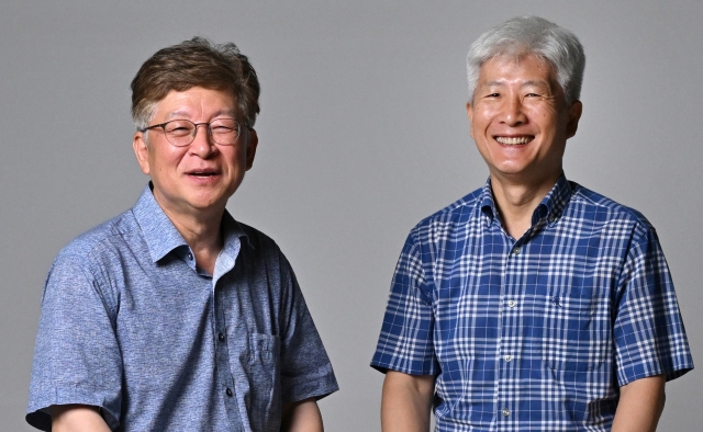 Kang Sung-jin, an economics professor at Korea University (left), and Jung Tae-yong, a professor at Yonsei University’s Graduate School of International Studies, pose for a photo during a round table meeting exploring Mongolia's business potential at Herald Square in Seoul on July 24. (Im Se-jun/The Korea Herald)