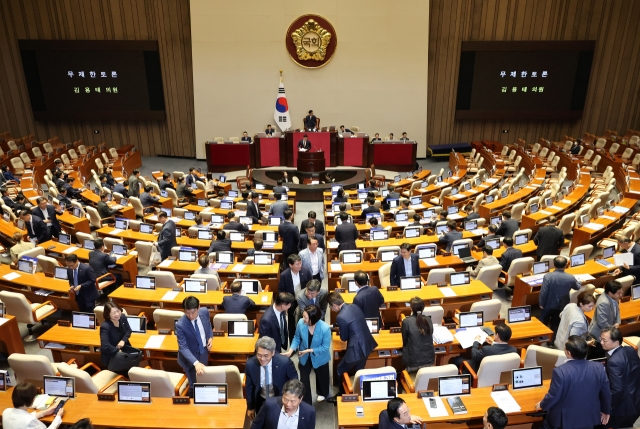 Opposition lawmakers leave a plenary session of the National Assembly in Seoul on Monday, as Rep. Kim Yong-tae of the ruling People Power Party begins to filibuster to block the passage of a revision to a broadcasting law. (Yonhap)