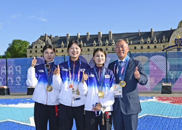 From left: South Korean national archers Nam Su-hyeon, Lim Si-hyeon and Jeon Hun-young and Hyundai Motor Group Executive Chair Chung Euisun pose for a photo after the team won the gold medal in the women's archery team event at the 2024 Summer Olympics in Paris on Sunday. (Korea Archery Association)