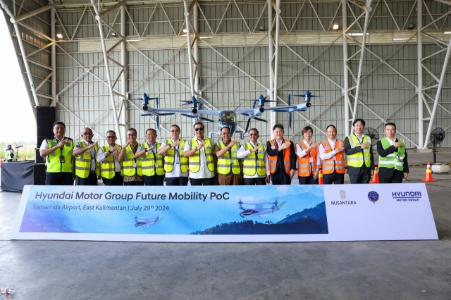 Officials from Hyundai Motor Group, Indonesia’s Ministry of Transportation and Nusantara Capital City Authority pose for a photo in front of a miniature S-A2 aircraft at Samarinda Airport in East Kalimantan, Indonesia on Monday. (Hyundai Motor Group)