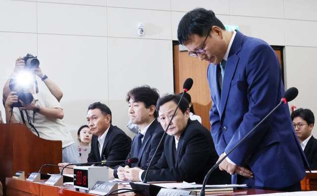 Qoo10 CEO Ku Young-bae (far right) bows is head in apology during a hearing at t he National Assembly’s Political Affairs Committee on Tuesday. (Yonhap)