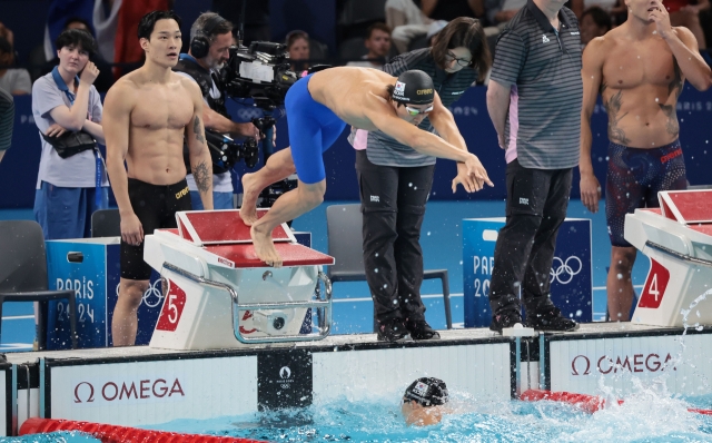 Kim Woo-min of South Korea (second from left) jumps into the pool as the South Korean anchor during the heats for the men's 4x200-meter freestyle relay swimming event at the Paris Olympics at Paris La Defense Arena in Nanterre, France, Tuesday. (Yonhap)