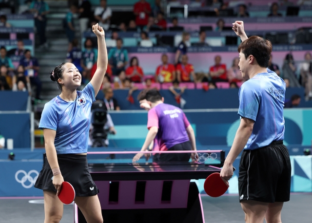 Shin Yu-bin (left) and Lim Jong-hoon of South Korea celebrate a point against Wong Chun Ting and Doo Hoi Kem of Hong Kong during the bronze medal match in the mixed doubles table tennis event at the Paris Olympics at South Paris Arena 4 in Paris on Tuesday. (Yonhap)