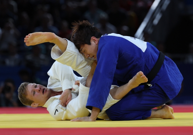 Lee Joon-hwan of South Korea (right) battles Matthias Casse of Belgium in the bronze medal match of the men's -81-kilogram judo event at the Paris Olympics at Champ-de-Mars Arena in Paris on Tuesday. (Yonhap)