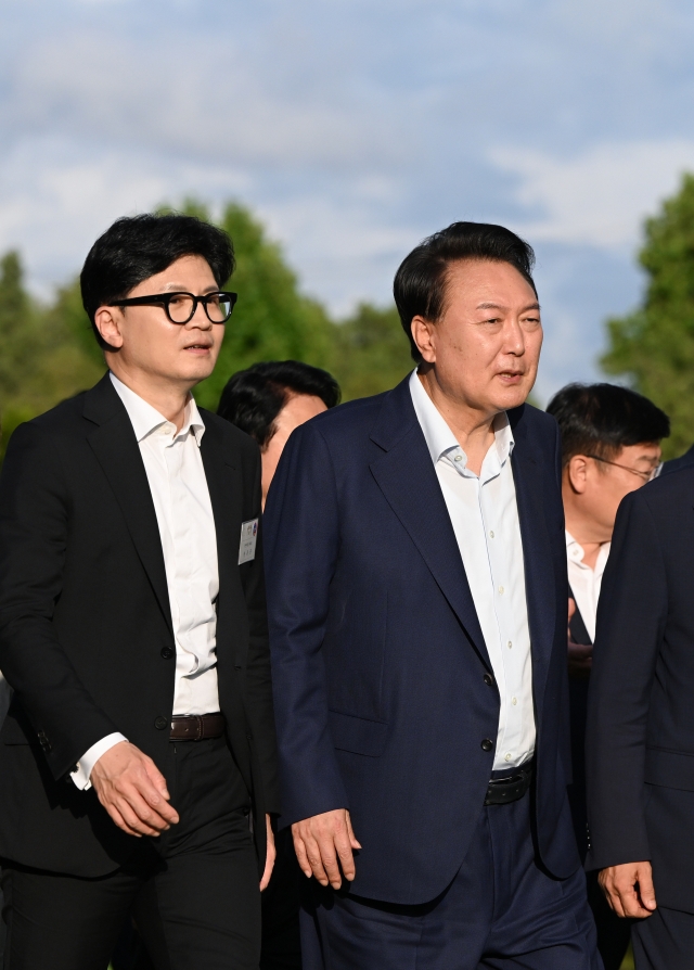 President Yoon Suk Yeol (right) and People Power Party Chair Han Dong-hoon stroll along as they attend a dinner hosted by the presidential office on July 24. (Presidential Office)