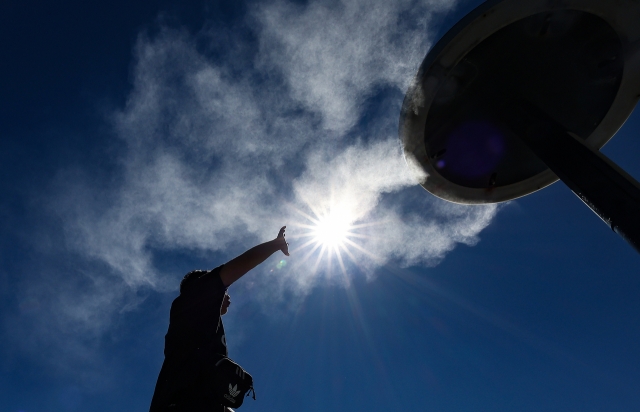 A person reaches toward cooling mist in Daegu on Wednesday, where daytime temperatures hit 37 degrees Celsius. (Yonhap)