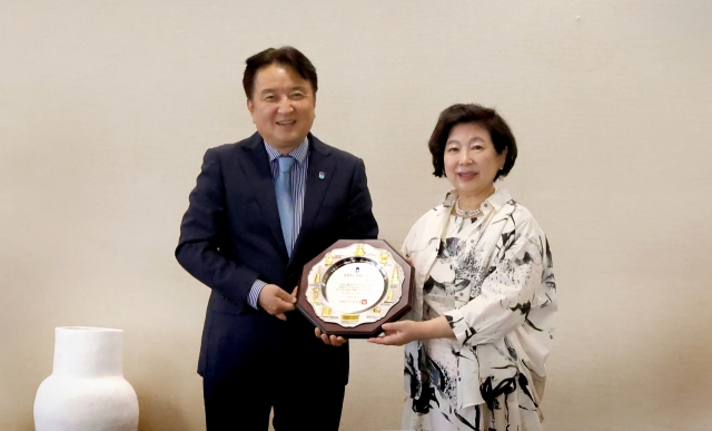 Kim Yong-hwan, governor of North Chungcheong Province, and Hyundai Group Chairperson Hyun Jeong-eun (right) pose for a photo upon Hyun's reappointment as an honorary governor of the province at the group's headquarters in central Seoul on Wednesday. (Hyundai Group)