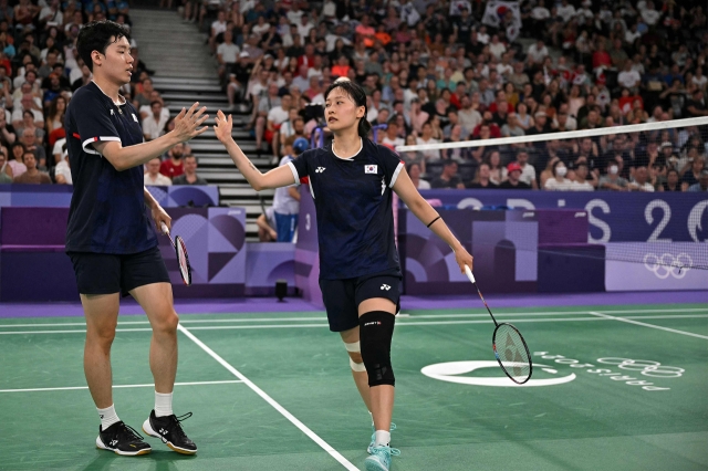 South Korea's Seo Seung-jae (L) shakes hands with Chae Yu-jung in the mixed doubles badminton quarter-final match against Hong Kong during the Paris 2024 Olympic Games at Porte de la Chapelle Arena in Paris on Wednesday. (AFP-Yonhap)