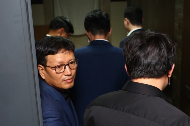 Qoo10 CEO Ku Young-bae (left) and investigators from local prosecution enter Ku's house for a search-and-seizure operation on Thursday. (Yonhap)