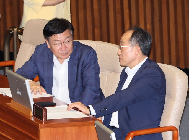 People Power Party policy chief Rep. Jeong Jeom-sig, left, talks to People Power Party Floor Leader Rep. Choo Kyung-ho during a parliamentary plenary session held Thursday afternoon at the National Assembly in western Seoul. (Yonhap)