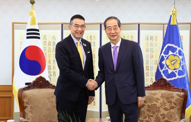 South Korean Prime Minister Han Duck-soo (R) shakes hands with Thailand's Foreign Minister Maris Sangiampongsa ahead of their meeting at his office in Seoul on Thursday in this photo provided by Han's office. (Yonhap)