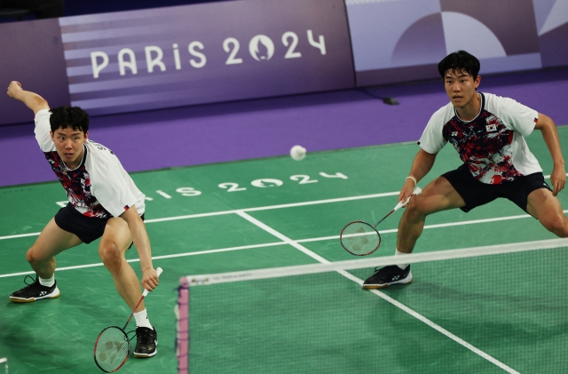 Kang Min-hyuk (right) and Seo Seung-jae of South Korea play against Kim Astrup and Anders Skaarup Rasmussen of Denmark in the quarterfinals of the men's doubles badminton event at the Paris Olympics at La Chapelle Arena in Paris on Thursday. (Reuters-Yonhap)